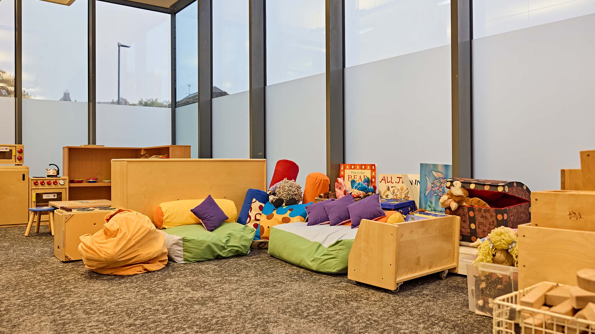 Primary teaching room with books, seating and play kitchen