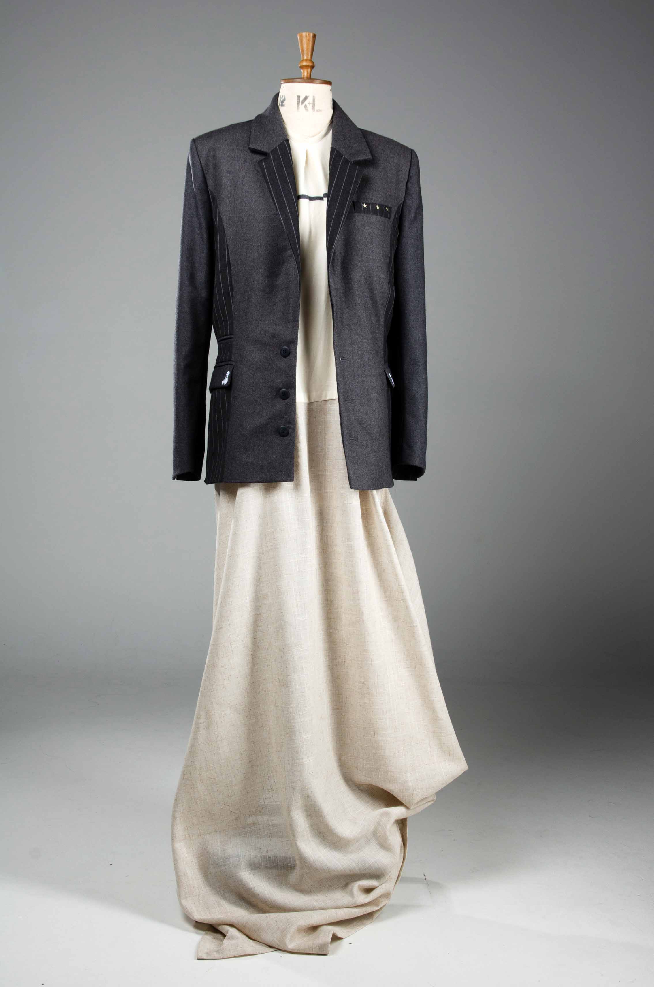 Student fashion design on a mannequin featuring a long white dress and black blazer
