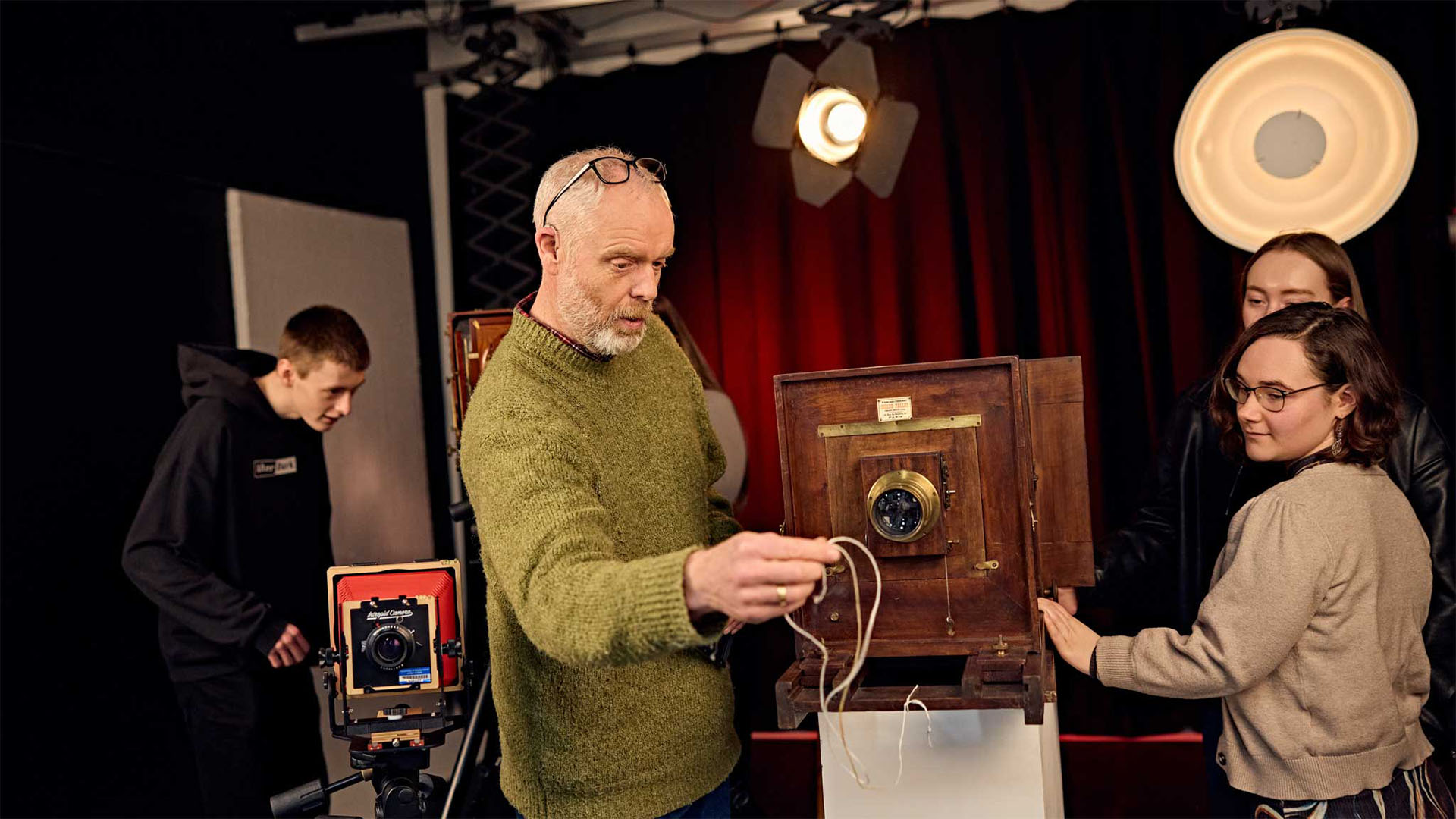 Students working with a large vintage film camera