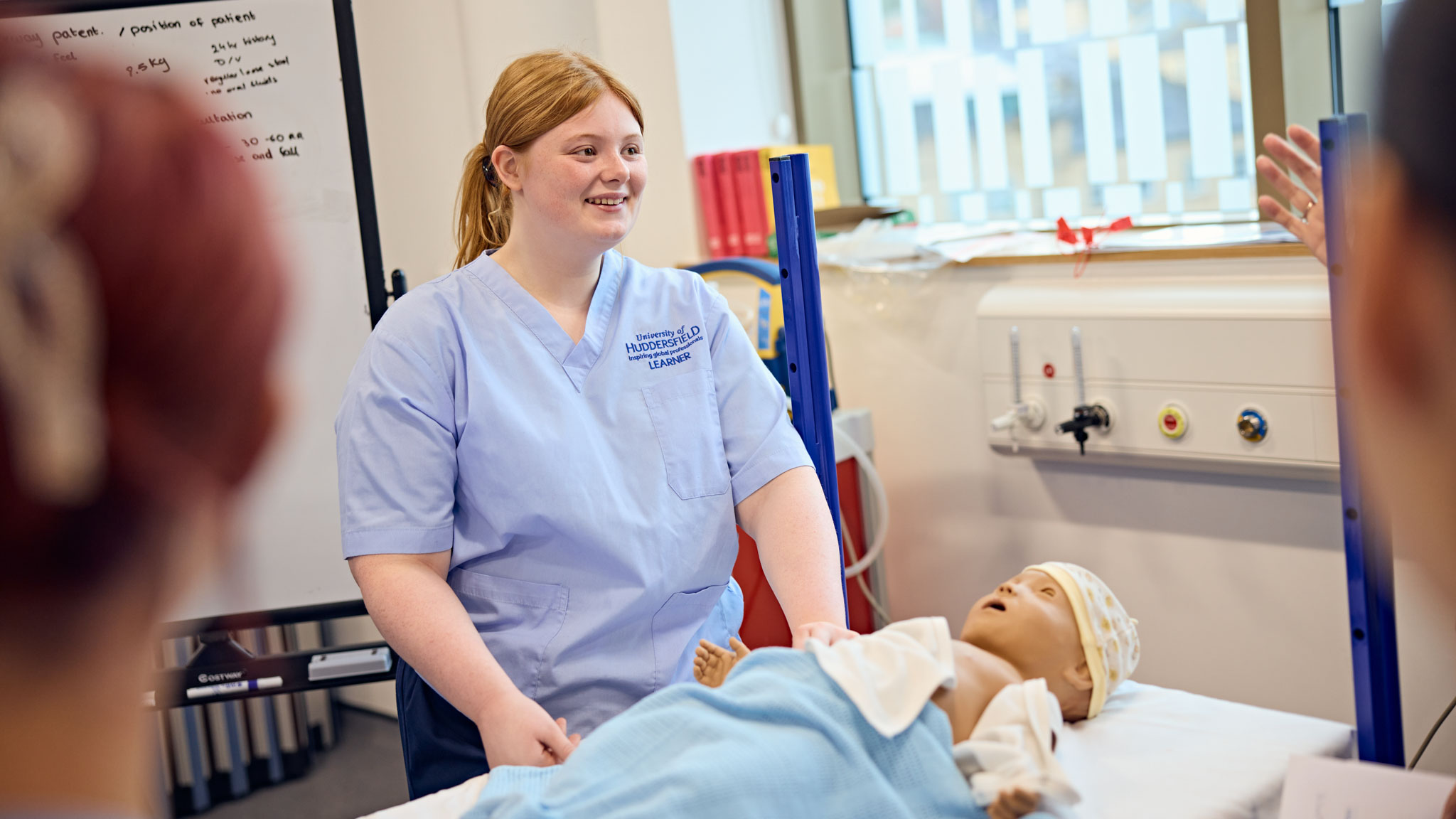 A student nurse learning with the help of a simulated hospital environment